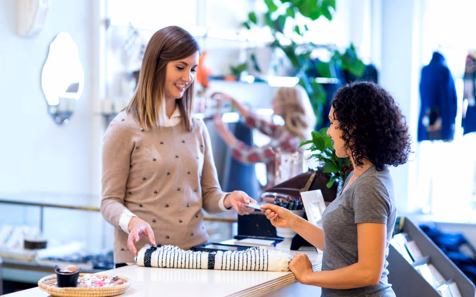 Business owner handing customer a paper punch card at checkout counter.